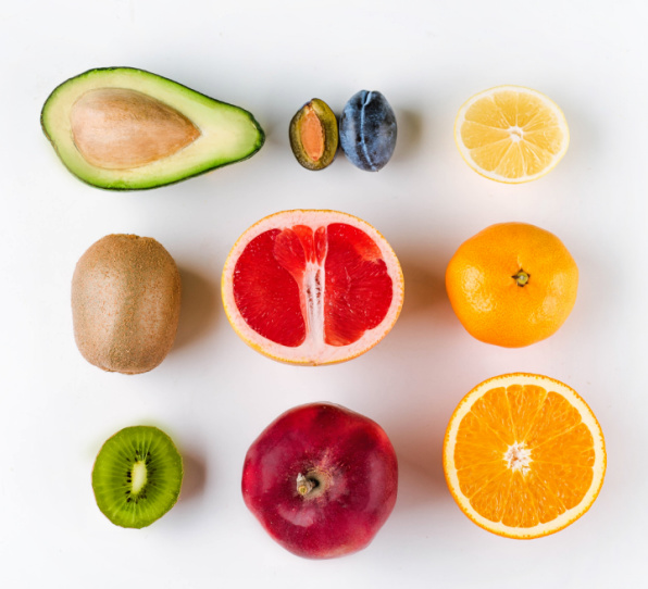 Closeup of apple with blue measuring tape holded by young sportswoman over white background